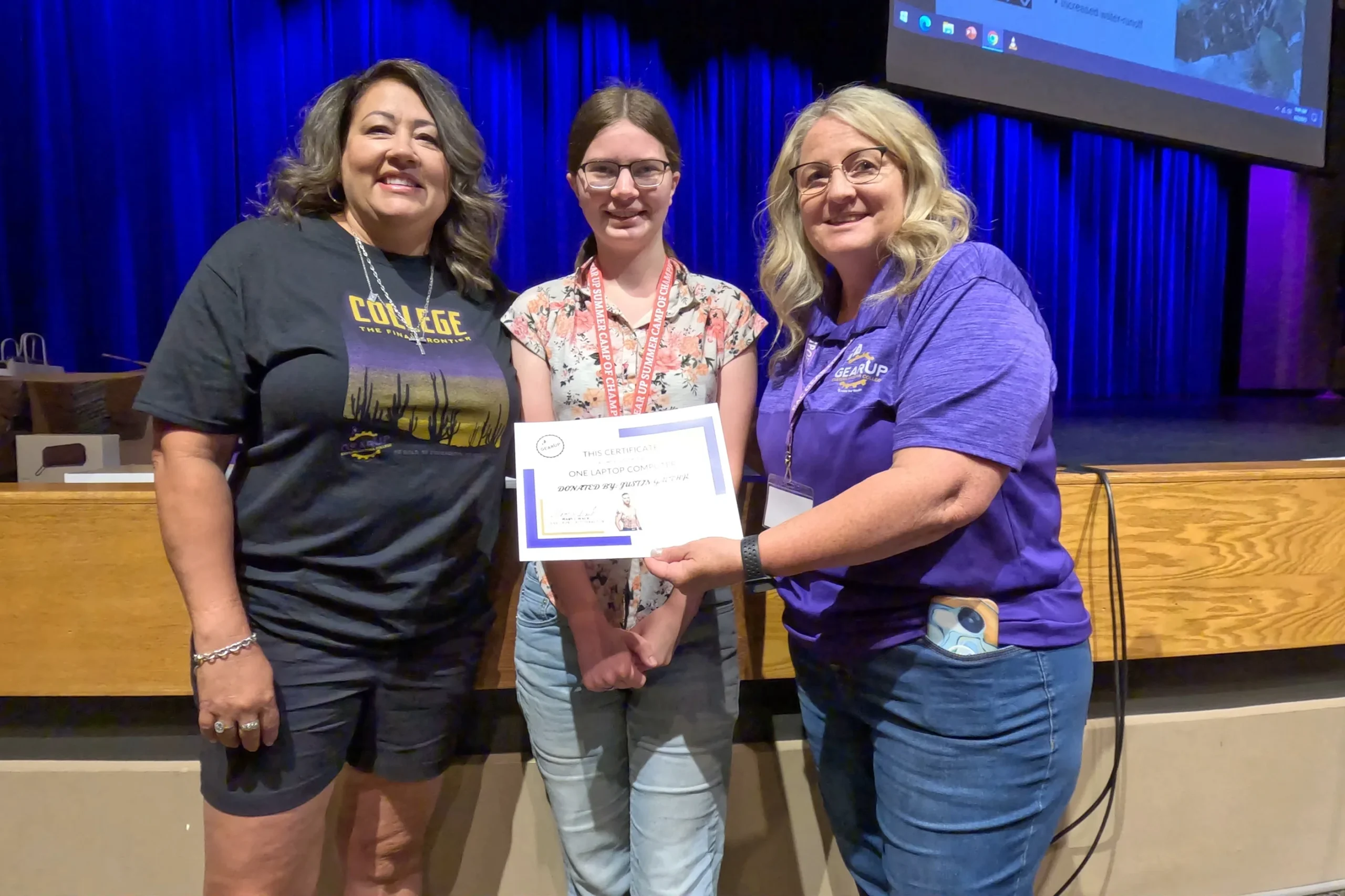 Carolina Gaethje (left) and Mary Wack (right) award Veronica Walker a certificate for one of two laptop computers dontated by Justin Gaethje.