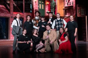 Cast of 'The Play that Goes Wrong' in costume on the stage.