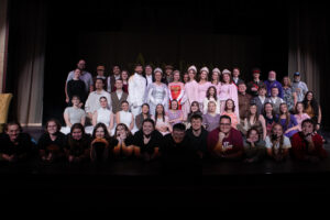 Anastatia cast and crew standing on stage.
