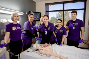 EAC nursing students in classroom practicing CPR.