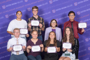 Group of people holding scholarship certificates.