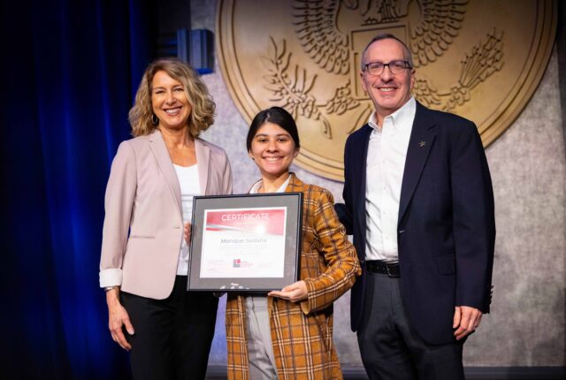 Monique Saldaña receives a certificate for graduating from The National Leadership Institute